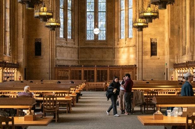 People in a library with beautiful architecture.