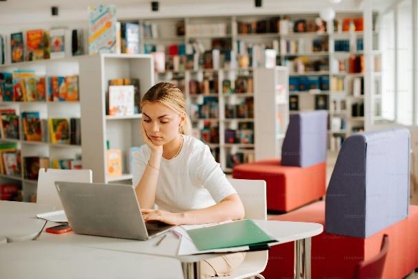 a woman sitting at a table using a laptop computer